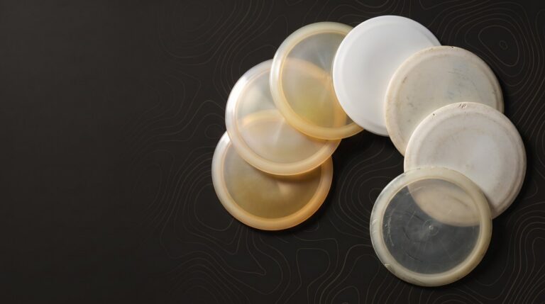 Seven worn golf discs fanned out on a dark background